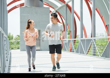 Joyeux jeune couple vietnamien jogging à l'extérieur Banque D'Images