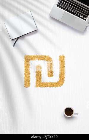 Flat Lay au sujet de gagner de l'argent à la maison avec un signe Shekel fait en paillettes dorées Banque D'Images