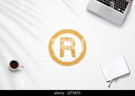 Scène à propos des marques déposées sur un bureau à domicile, avec un symbole en paillettes dorées Banque D'Images