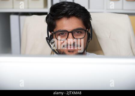 Portrait d'un jeune homme d'affaires indien joyeux travaillant au service d'assistance Banque D'Images