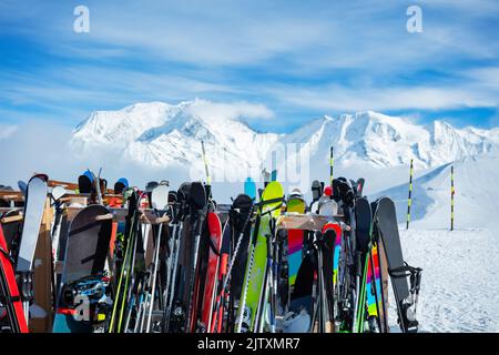 De nombreux skis se tiennent sur la station alpine au-dessus des sommets de montagne Banque D'Images