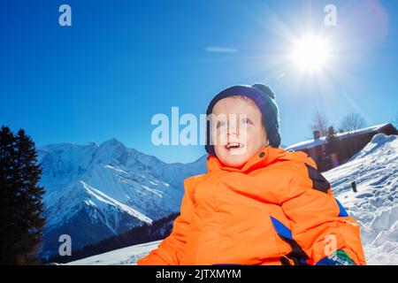 Portrait rapproché d'un petit garçon souriant sur des montagnes enneigées Banque D'Images