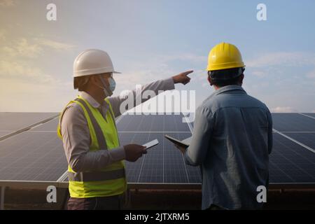 Ingénieur travaillant avec des travailleurs travaillant en équipe dans le cadre d'un panneau solaire, un concept d'énergie renouvelable. Banque D'Images