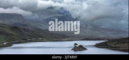 Nuages qui se balassent sur Old Man of Storr sur l'île de Skye, en Écosse, au Royaume-Uni. Paysage panoramique avec ciel nuageux sur montagne et lac avec si Banque D'Images