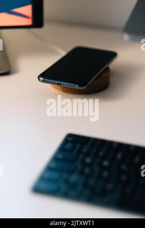 Un téléphone en cours de chargement sur un périphérique de chargement sans fil Banque D'Images