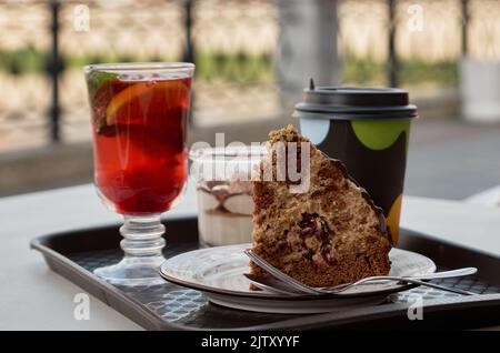 Street STILL Life: Tasse de thé avec baie, paix de gâteau et de carton café tasse sur plateau en plastique dans la rue café Banque D'Images