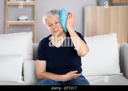 Main de femme appliquant le gel glacé Pack sur la tête Banque D'Images