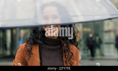 Portrait de la belle mignonne flirting brunette femme avec les cheveux bouclés jolie fille touriste avec parapluie transparent posant sur la rue dans la ville dans la pluie Banque D'Images