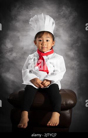 Une petite fille en chef cuisinier en tenue de portrait. Fille philippine-asiatique. Banque D'Images