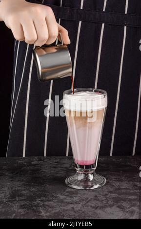gros plan d'un barista qui prépare un café au sirop et à la mousse de crème dans un magasin ou un café Banque D'Images