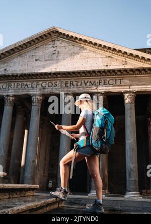 Photo verticale de la jeune femme tient sa carte de Rome pour découvrir la ville et mieux la connaître, nomade numérique Banque D'Images