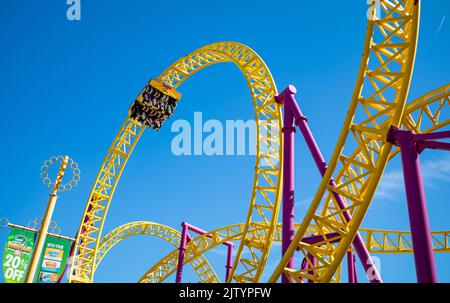 Les gens voyagent à l'envers sur une promenade en montagnes russes appelée « rage » à Adventure Island, un parc d'attractions et de foire situé sur le front de mer à côté de Southen Banque D'Images