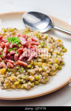 porridge de légumineuses avec bacon frit et ciboulette Banque D'Images