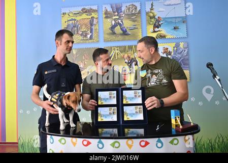 Irpin, Ukraine. 01st septembre 2022. Le président ukrainien Volodymyr Zelenskyy, au centre, tient le nouveau timbre-poste en l'honneur de Patron, le chien qui a briffé la bombe, parti, lors d'une cérémonie à l'école secondaire A. S. Makarenko, 1 septembre 2022 à Irpin, en Ukraine. En partant de la gauche : Mykhailo Iliev et son chien patron, le président ukrainien Volodymyr Zelenskyy et le directeur d'Ukrposhta Ihor Smilianski. Credit: Sarsenov Daniiar/Présidence ukrainienne/Alamy Live News Banque D'Images