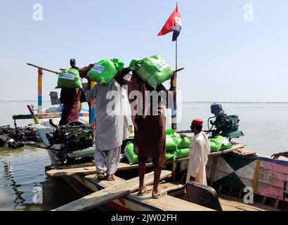 Hyderabad, Pakistan. 02nd septembre 2022. Les agents de police transportent des secours car ils vont distribuer des secours aux personnes touchées par les inondations en utilisant des bateaux en raison des inondations causées par un fort déluge de la saison de la mousson, à Soukkur vendredi, au 02 septembre 2022. Credit: Asianet-Pakistan/Alamy Live News Banque D'Images