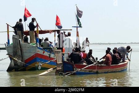 Hyderabad, Pakistan. 02nd septembre 2022. Les agents de police transportent des secours car ils vont distribuer des secours aux personnes touchées par les inondations en utilisant des bateaux en raison des inondations causées par un fort déluge de la saison de la mousson, à Soukkur vendredi, au 02 septembre 2022. Credit: Asianet-Pakistan/Alamy Live News Banque D'Images