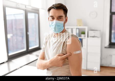 patient mâle dans le masque avec patch après la vaccination Banque D'Images