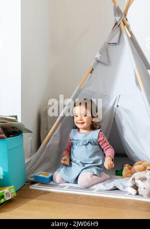 bébé fille jouant dans la tente d'enfants ou tipi à la maison Banque D'Images