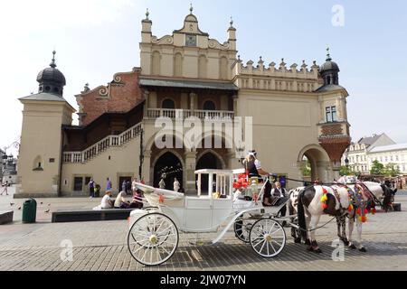 Calèche offrant des promenades aux touristes sur la place du marché, Cracovie, Pologne Banque D'Images