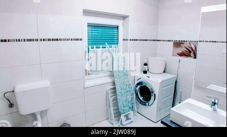 Salle de lavage moyenne avec planche à repasser contre le mur Banque D'Images