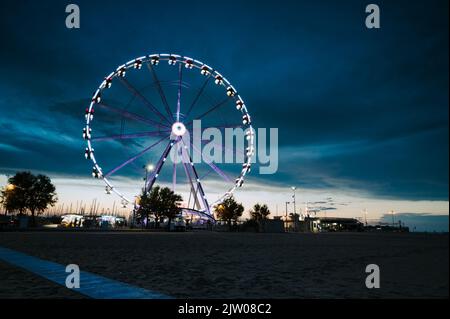 Italie, septembre 2022 : vue sur la grande roue de Rimini avec toutes les lumières colorées près de la plage de la Riviera Romagnola Banque D'Images