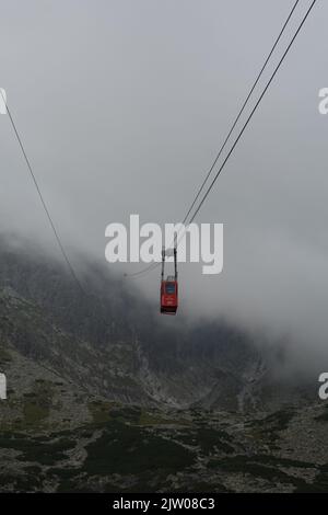 Téléphérique disparaissant dans les nuages lors de son voyage à Lomnicky Stit, High Tatras Slovaquie, Europe Banque D'Images