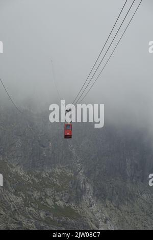 Téléphérique disparaissant dans les nuages lors de son voyage à Lomnicky Stit, High Tatras Slovaquie, Europe Banque D'Images