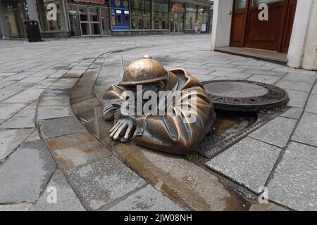 Cumil la statue de l'ouvrier d'égouts par le sculpteur Viktor Hulik, dans un trou d'homme, Bratislava, Slovaquie, Europe Banque D'Images