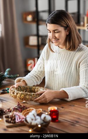 femme qui fait une couronne de noël à la maison Banque D'Images