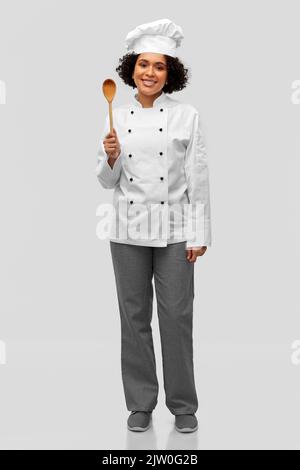 femme souriante chef avec cuillère en bois Banque D'Images