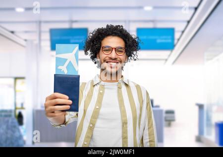 homme heureux avec passeport et billet d'avion à l'aéroport Banque D'Images