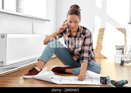 femme avec blueprint appelant sur smartphone à la maison Banque D'Images