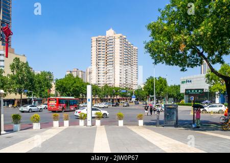 Paysage urbain dans le quartier du centre-ville. Un immeuble d'appartements est au loin. Un bus et des voitures conduisent sur l'avenue de la ville Banque D'Images