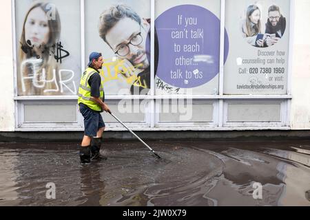 Les travailleurs nettoient une inondation éclair près d'Euston après de fortes pluies d'ambre à Londres hier après-midi. Un système de vidange est utilisé pour pomper l'eau sur le Banque D'Images