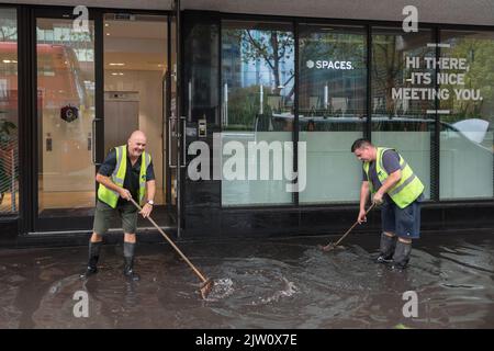 Les travailleurs nettoient une inondation éclair près d'Euston après de fortes pluies d'ambre à Londres hier après-midi. Un système de vidange est utilisé pour pomper l'eau sur le Banque D'Images