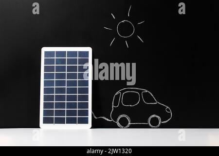 batterie solaire et voiture électrique sur tableau noir Banque D'Images