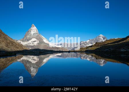 Le majestueux Matterhorn, la plus célèbre montagne de Suisse, se reflète dans le lac Riffel tôt le matin dans un paysage écrasant. Banque D'Images