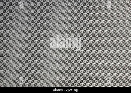 Gros plan de tissu synthétique texturé à motif losanges utilisé pour fabriquer des stores. Modèle de conception ou fond abstrait en polyester. Banque D'Images
