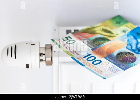 Argent, francs suisses se trouvant sur le radiateur, concept, coûts de chauffage des appartements en hiver pendant l'inflation, augmentations des prix de l'énergie Banque D'Images