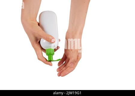 Une femme qui appuie sur la pompe du flacon distributeur tout en appliquant du savon sur les mains sur fond blanc Banque D'Images