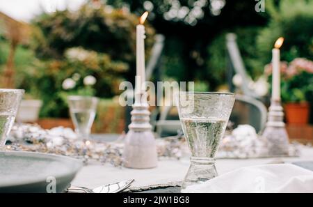 bougies allumées et verre de vin sur une table à dîner décorée Banque D'Images