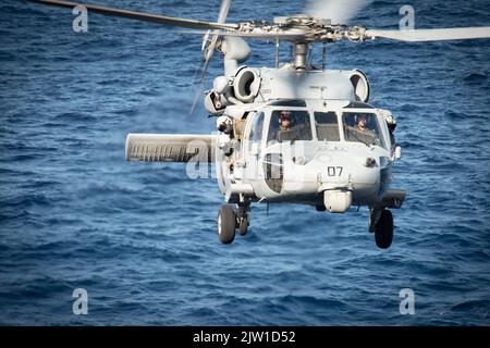 MER DE CHINE ORIENTALE (AOÛT 31, 2022) un hélicoptère MH-60s Sea Hawk, de l'Escadron de combat de la mer d'hélicoptère (HSC) 25, détachement 6, se prépare à atterrir sur le pont de vol du porte-avions amphibie déployé par l'avant USS America (LHA 6) alors qu'il était en cours en mer de Chine orientale, le 31 août 2022. L'Amérique, navire chef de file du America Amphiobie Ready Group, opère dans la zone d'opérations 7th de la flotte pour améliorer l'interopérabilité avec ses alliés et ses partenaires et servir de force de réaction prête à l'emploi pour défendre la paix et la stabilité dans la région Indo-Pacifique. (É.-U. Photo de la marine par le spécialiste des communications de masse 3rd classe Sade Banque D'Images