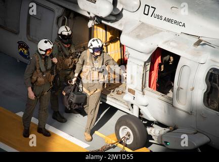 MER DE CHINE ORIENTALE (AOÛT 31, 2022) marins, affectés à l'Escadron de combat en mer (HSC) 25, détachement 6, débarquent un hélicoptère MH-60s Sea Hawk, du HSC 25, détachement 6, sur le pont de vol du transporteur d'assaut amphibie déployé par l'avant USS America (LHA 6) pendant les opérations de vol en mer de Chine orientale, le 31 août, 2022. L'Amérique, navire chef de file du America Amphiobie Ready Group, opère dans la zone d'opérations 7th de la flotte pour améliorer l'interopérabilité avec ses alliés et ses partenaires et servir de force de réaction prête à l'emploi pour défendre la paix et la stabilité dans la région Indo-Pacifique. (U. Banque D'Images