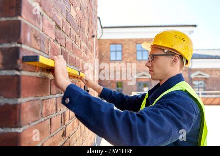 construction mâle avec mur de mesure de niveau Banque D'Images