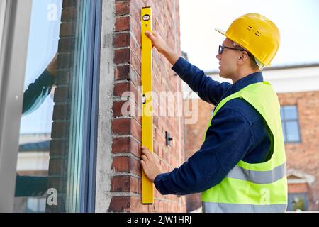 construction mâle avec mur de mesure de niveau Banque D'Images