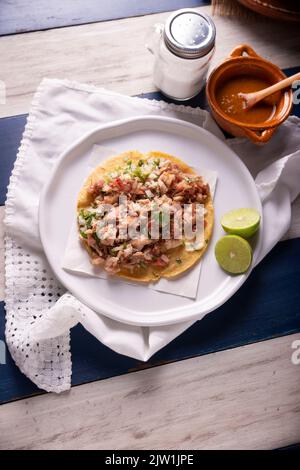 Taco de Carnitas. Tortilla au cornmeal avec porc frite. Apéritif mexicain traditionnel généralement accompagné de coriandre, d'oignon et de sauce chaude. Banque D'Images