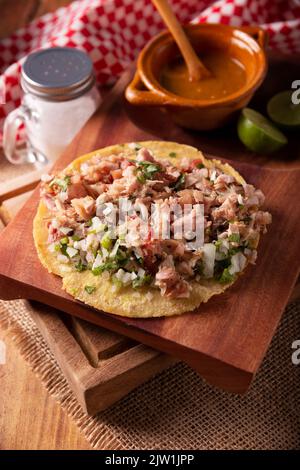 Taco de Carnitas. Tortilla au cornmeal avec porc frite. Apéritif mexicain traditionnel généralement accompagné de coriandre, d'oignon et de sauce chaude. Banque D'Images