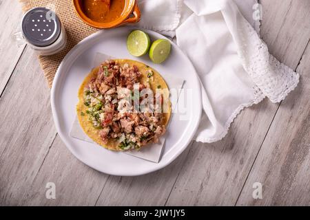 Taco de Carnitas. Tortilla au cornmeal avec porc frite. Apéritif mexicain traditionnel généralement accompagné de coriandre, d'oignon et de sauce chaude. Banque D'Images