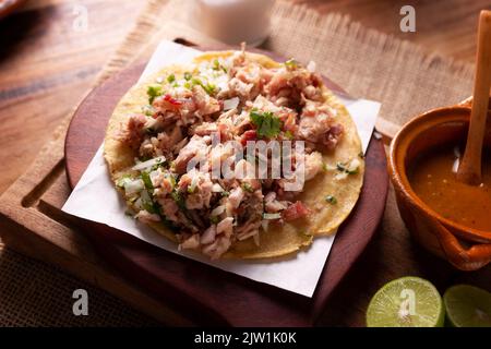 Taco de Carnitas. Tortilla au cornmeal avec porc frite. Apéritif mexicain traditionnel généralement accompagné de coriandre, d'oignon et de sauce chaude. Banque D'Images