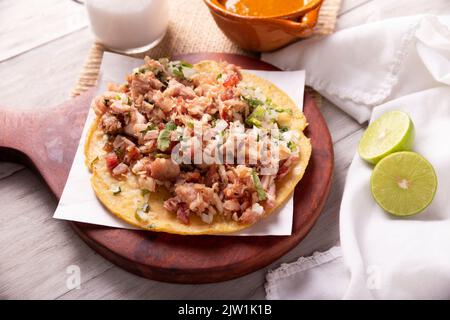 Taco de Carnitas. Tortilla au cornmeal avec porc frite. Apéritif mexicain traditionnel généralement accompagné de coriandre, d'oignon et de sauce chaude. Banque D'Images